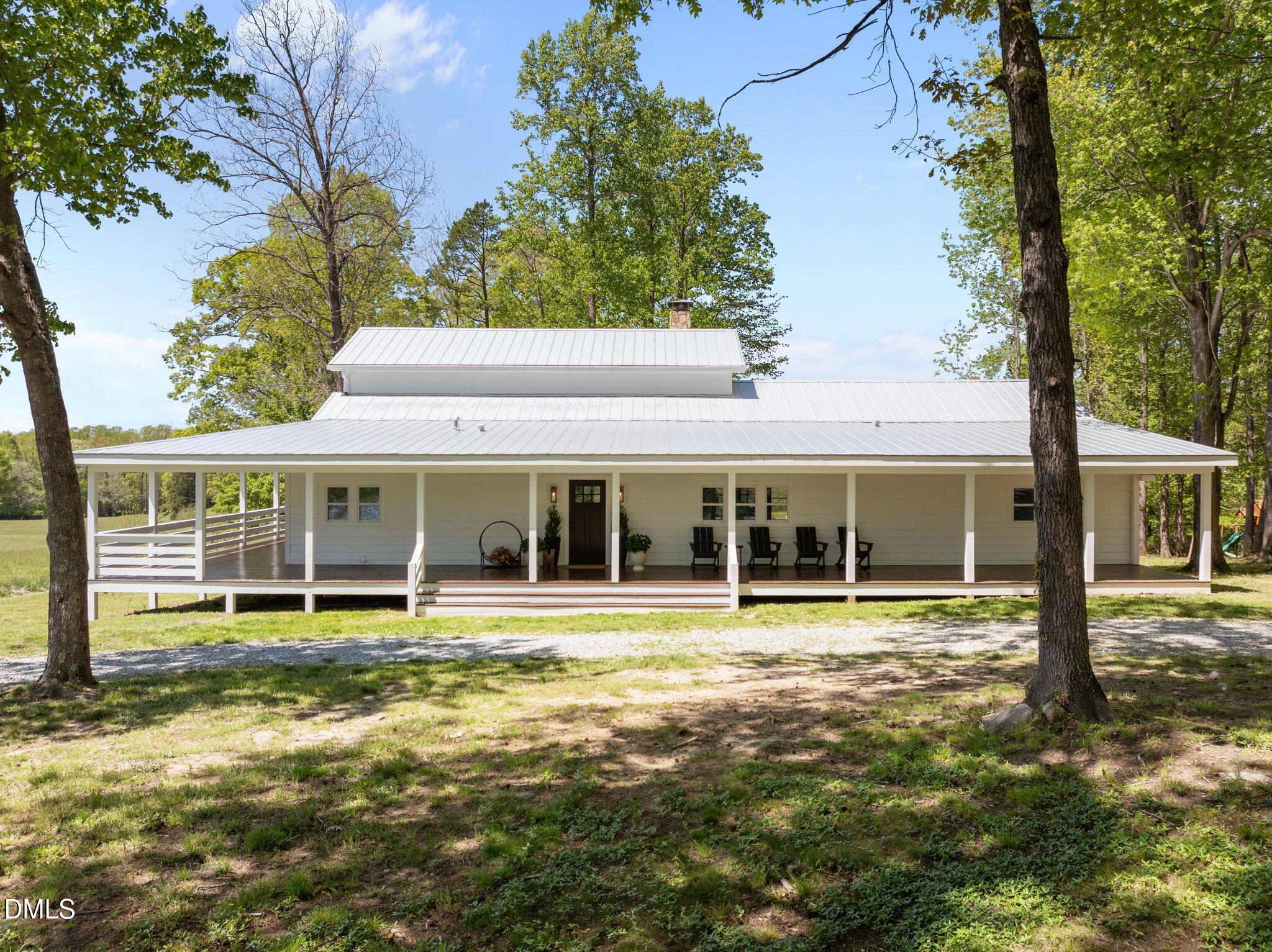 9400 Wheelers Church Road Cedar Grove, NC 27231 - Photo 53 of 96 a view of a white house with a big yard and large trees