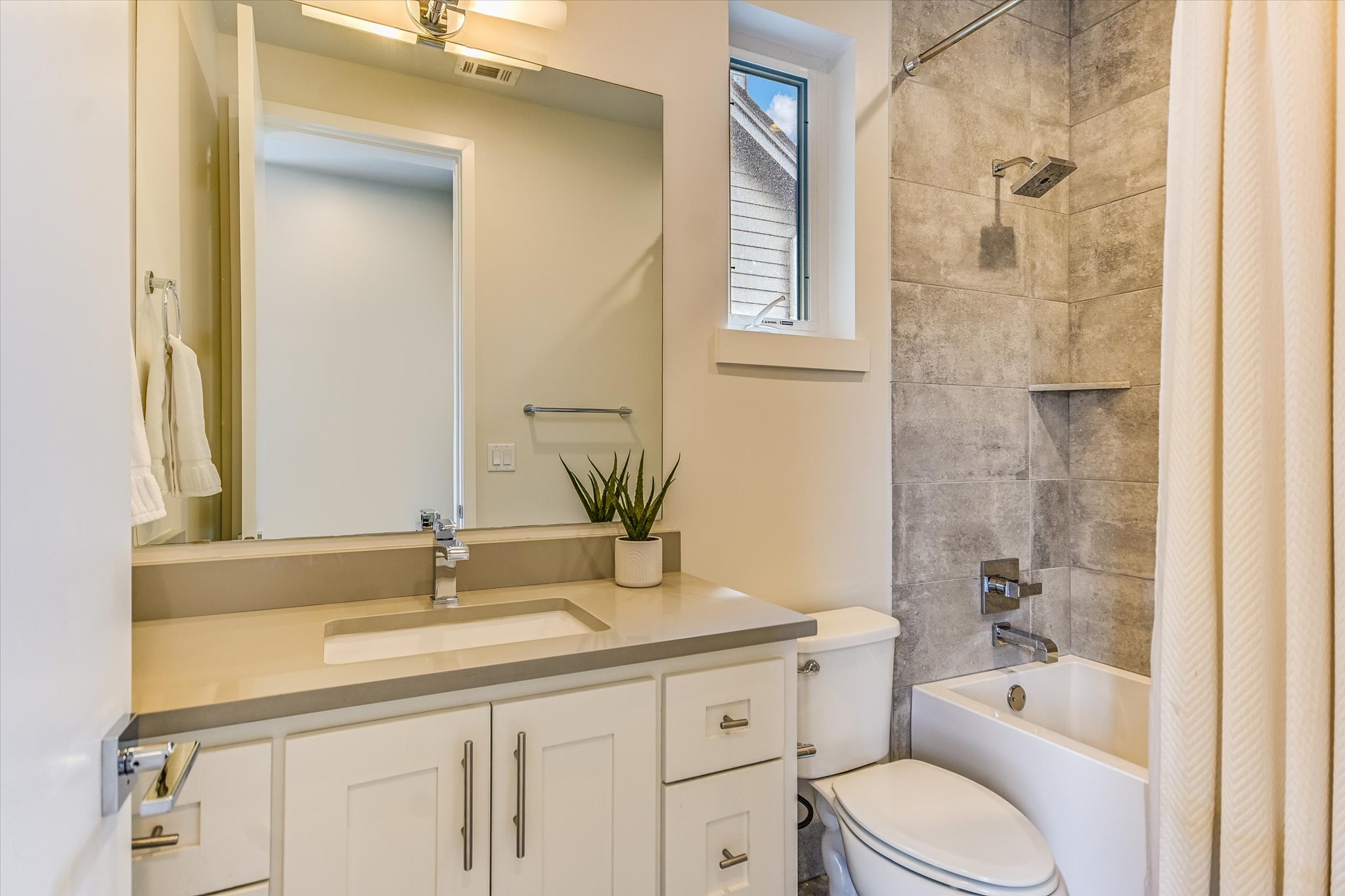 1605 Hether Street Austin, TX 78704 - Photo 20 of 26 Modern bathroom featuring a white vanity with shaker-style cabinetry, a light-toned countertop, and an undermount sink