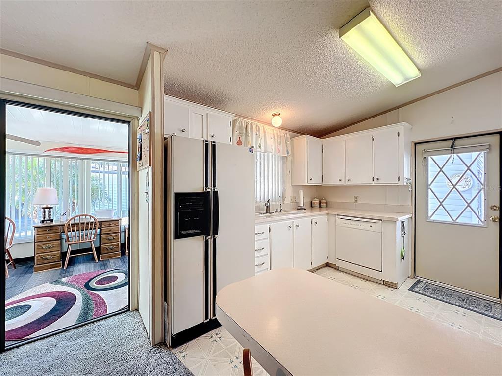 25125 Bellevue Leesburg, FL 34748 - Photo 13 of 44 a kitchen with a refrigerator a stove top oven and a sink