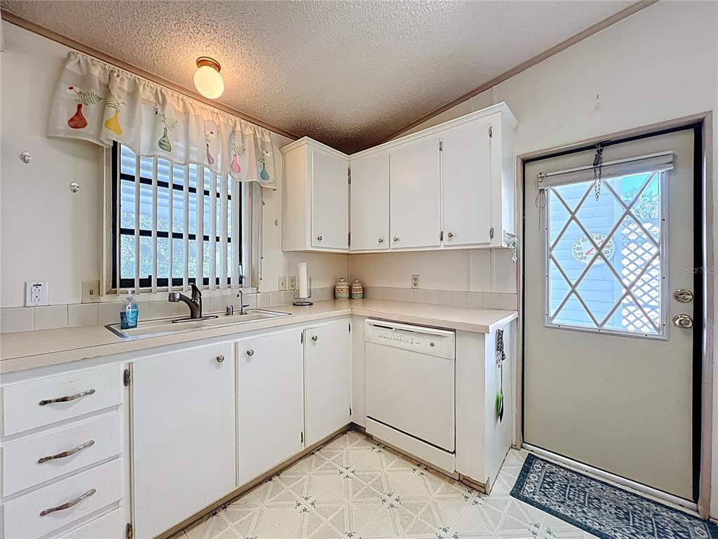25125 Bellevue Leesburg, FL 34748 - Photo 17 of 44 a kitchen with granite countertop white cabinets and white appliances