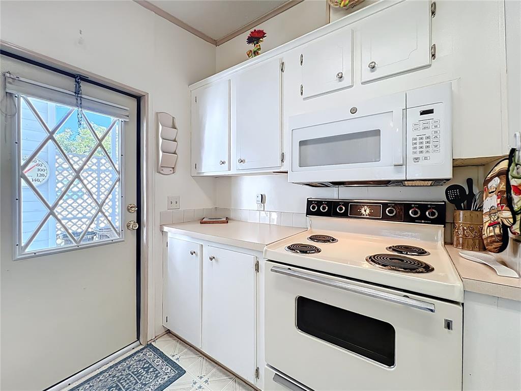 25125 Bellevue Leesburg, FL 34748 - Photo 19 of 44 a kitchen with granite countertop white cabinets and white appliances