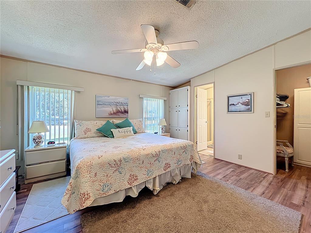 25125 Bellevue Leesburg, FL 34748 - Photo 23 of 44 a bedroom with a bed painting on wall and a large window