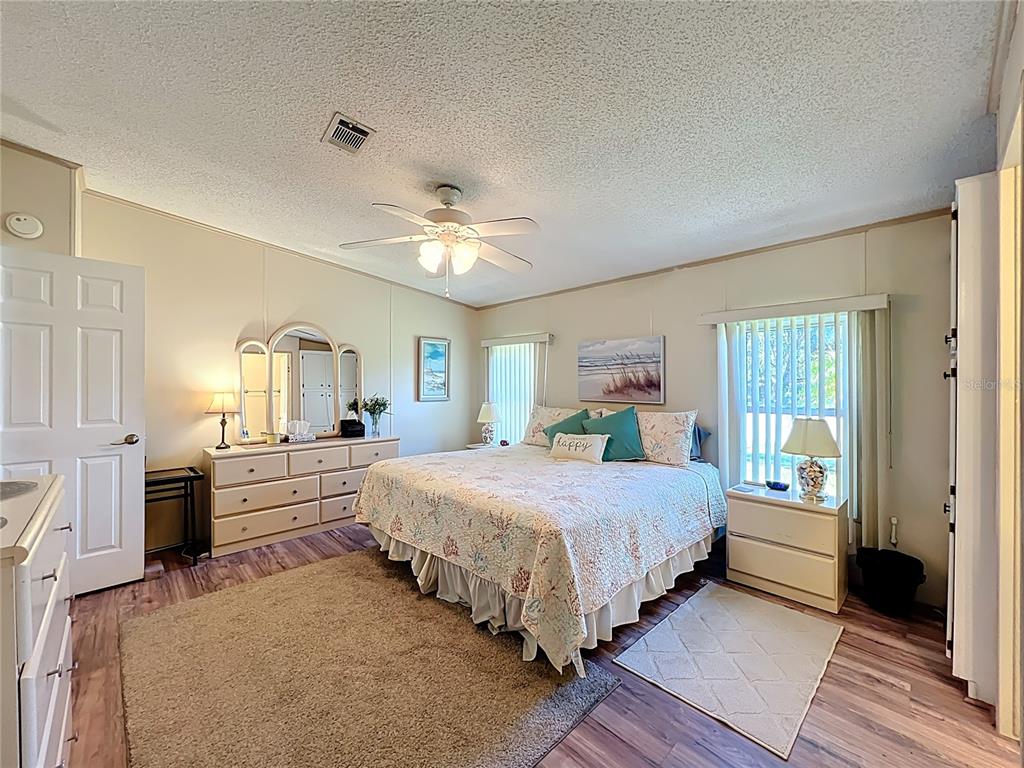 25125 Bellevue Leesburg, FL 34748 - Photo 24 of 44 a bedroom with a bed and a chandelier