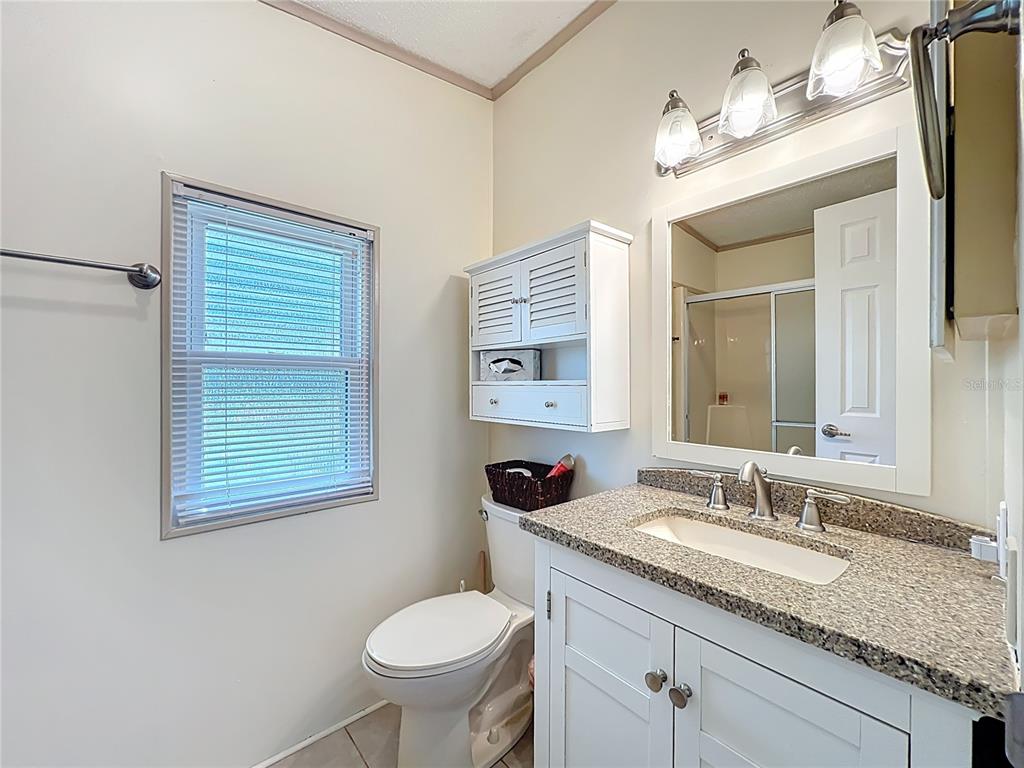 25125 Bellevue Leesburg, FL 34748 - Photo 27 of 44 a bathroom with a granite countertop sink toilet and a mirror