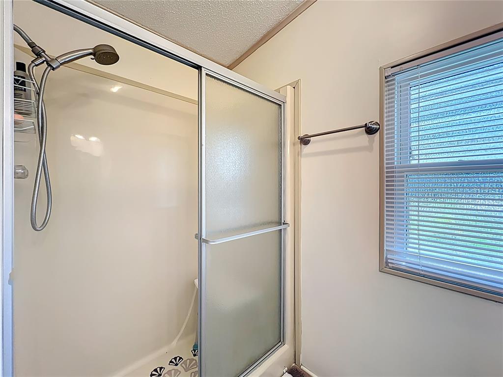 25125 Bellevue Leesburg, FL 34748 - Photo 28 of 44 a bathroom with a glass shower door