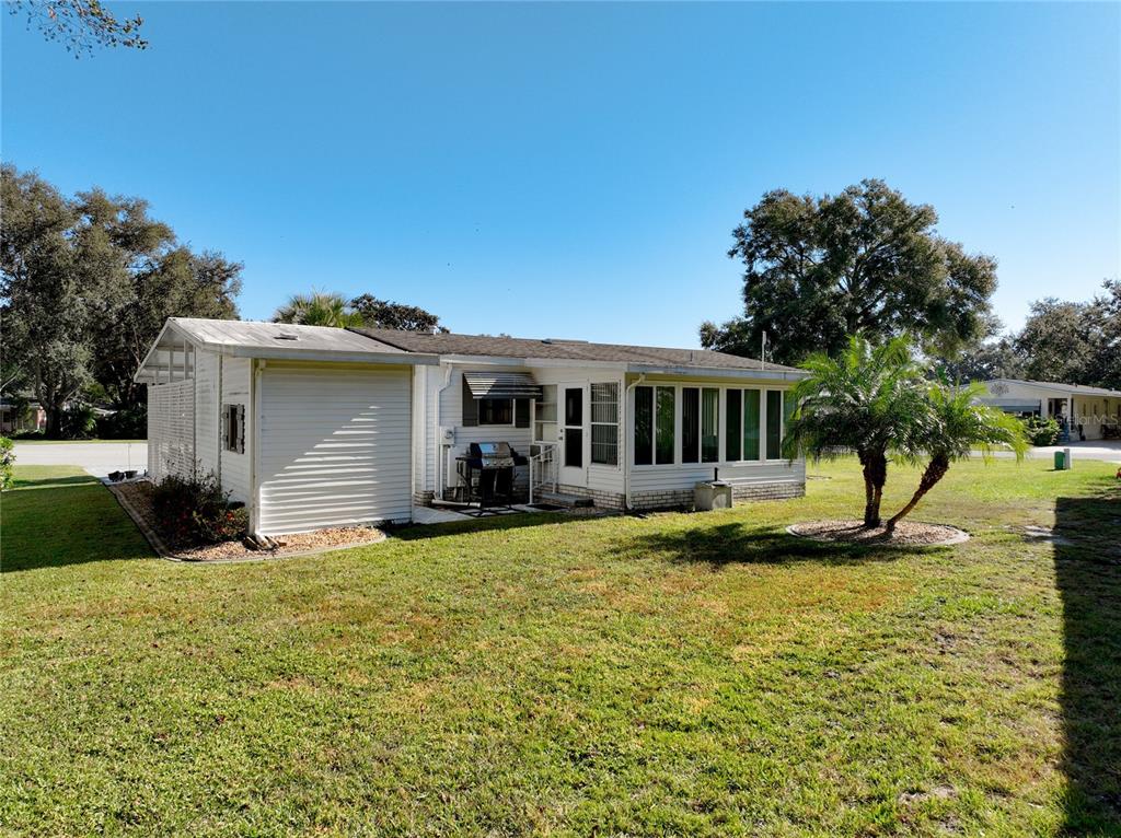 25125 Bellevue Leesburg, FL 34748 - Photo 39 of 44 a view of a house with a big yard and a large tree
