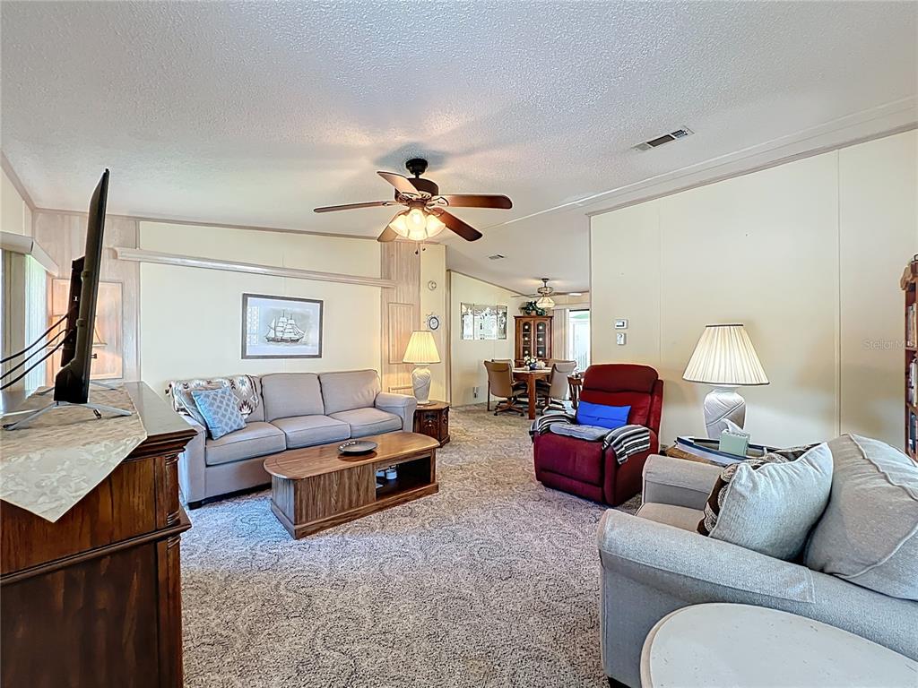 25125 Bellevue Leesburg, FL 34748 - Photo 6 of 44 a living room with furniture and a flat screen tv