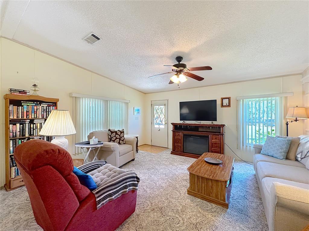 25125 Bellevue Leesburg, FL 34748 - Photo 7 of 44 a living room with furniture a flat screen tv and a large window