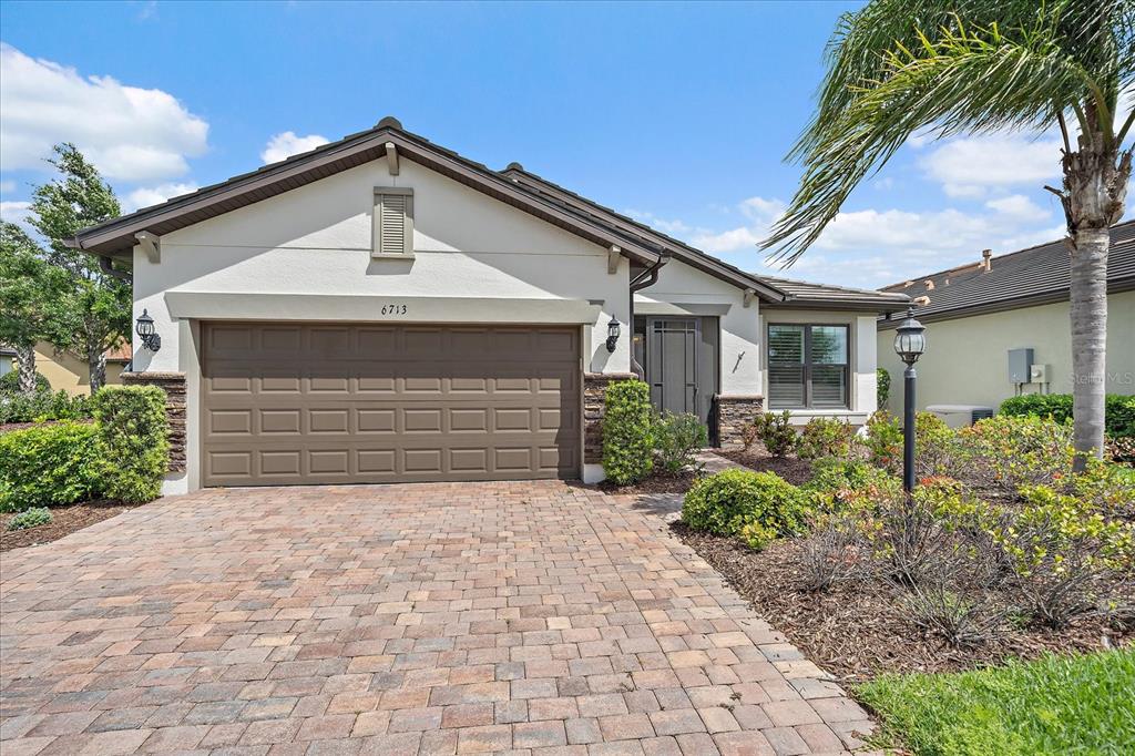 6713 Chester Trail Lakewood Ranch, FL 34202 - Photo 36 of 45 a front view of a house with a yard and garage
