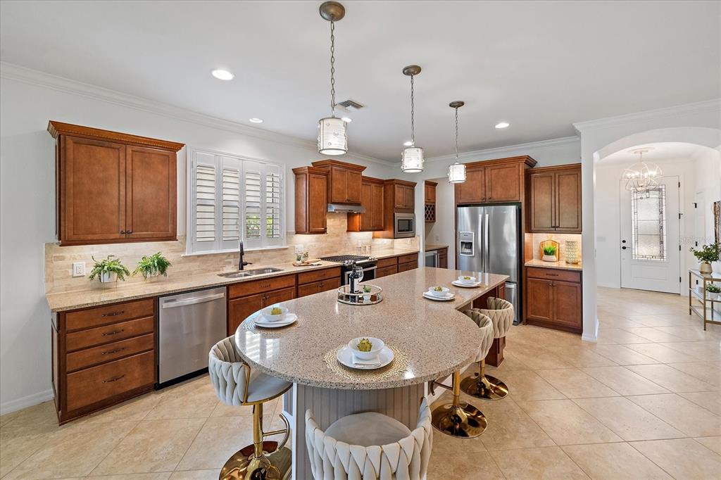 6713 Chester Trail Lakewood Ranch, FL 34202 - Photo 8 of 45 a kitchen with a sink a counter and chairs in it
