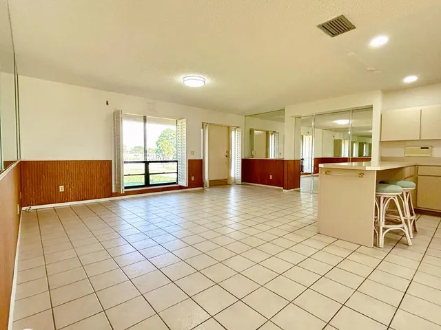 a bathroom with a granite countertop sink toilet mirror and bathtub