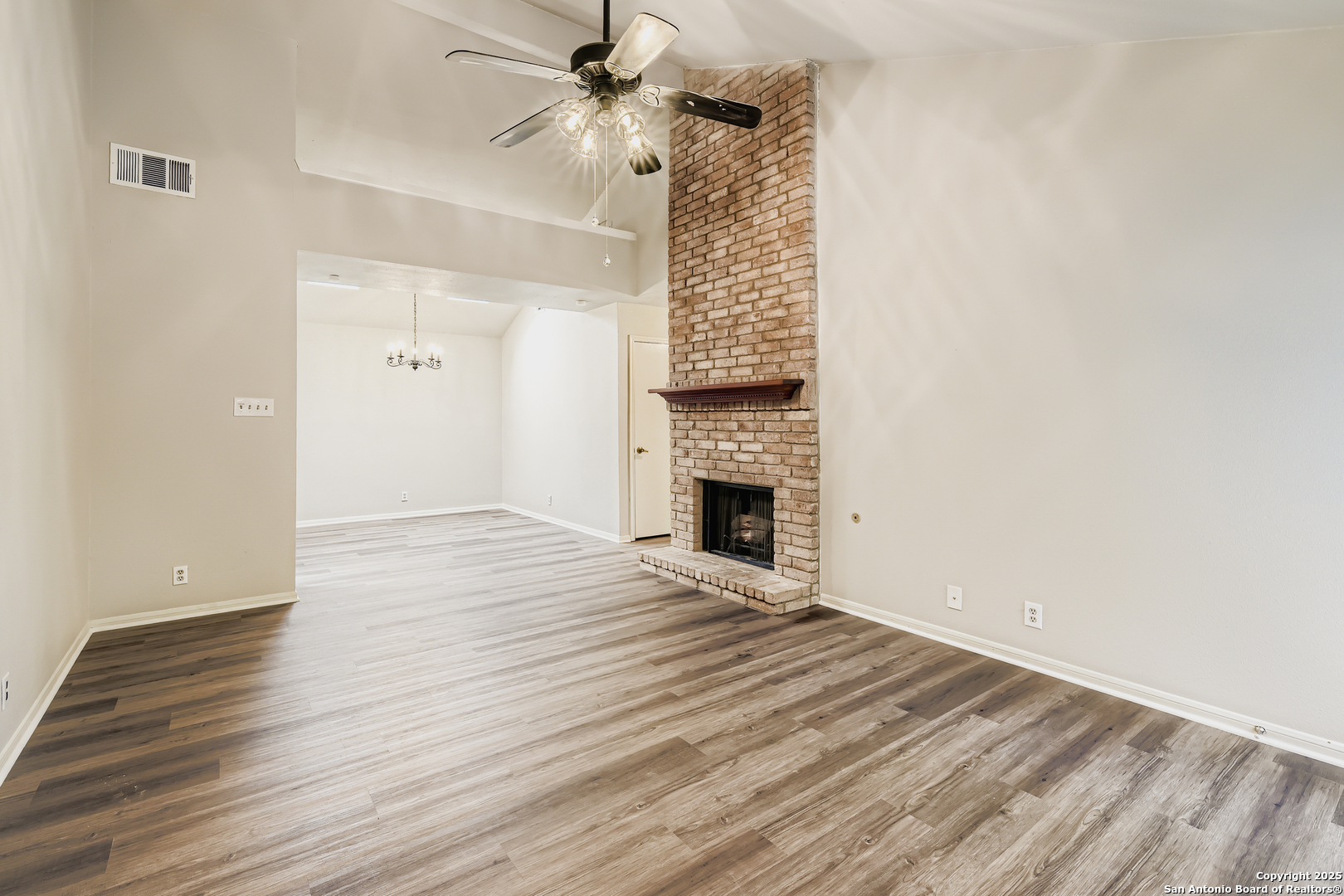 15018 Spring Shower San Antonio, TX 78247 - Photo 4 of 29 a view of an empty room with wooden floor a fireplace