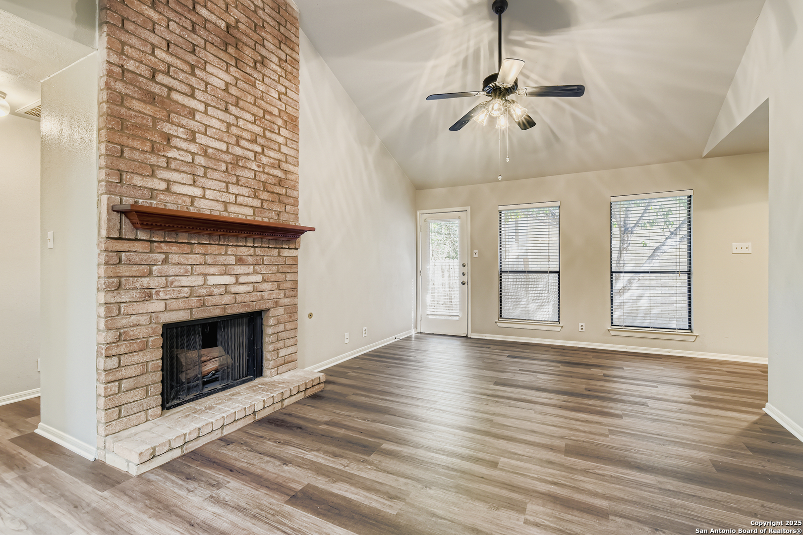 15018 Spring Shower San Antonio, TX 78247 - Photo 6 of 29 a view of an empty room with wooden floor fireplace and a window