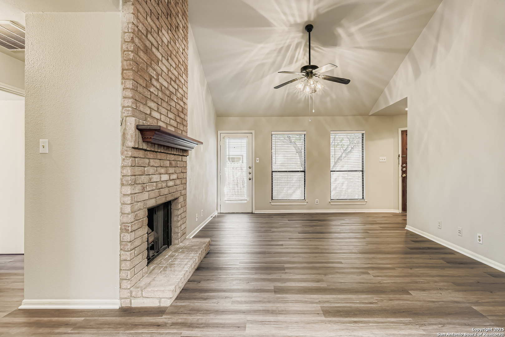15018 Spring Shower San Antonio, TX 78247 - Photo 7 of 29 a view of an empty room with wooden floor fireplace and a window