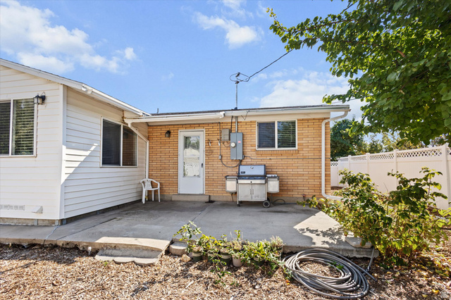 215 Carol Way Midvale, UT 84047 - Photo 27 of 30 Rear view of house with a patio area and brick siding