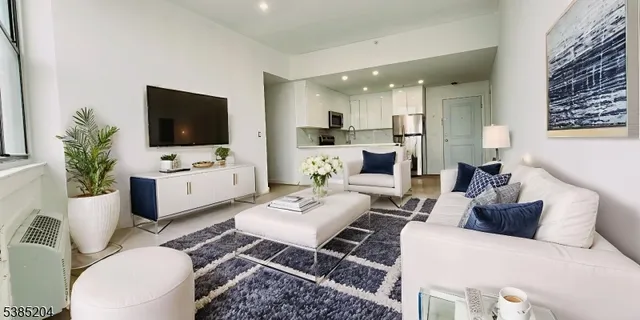 a living room with furniture a flat screen tv and a potted plant