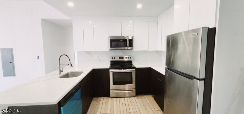 30 Howe Avenue, Unit 302 Passaic, NJ 07055 - Photo 3 of 10 a kitchen with a refrigerator and a sink