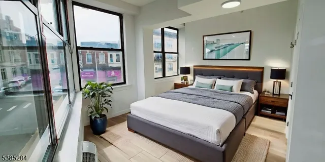 a bedroom with a large bed and a potted plant