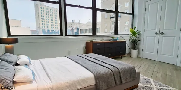 a bedroom with a bed and a large window