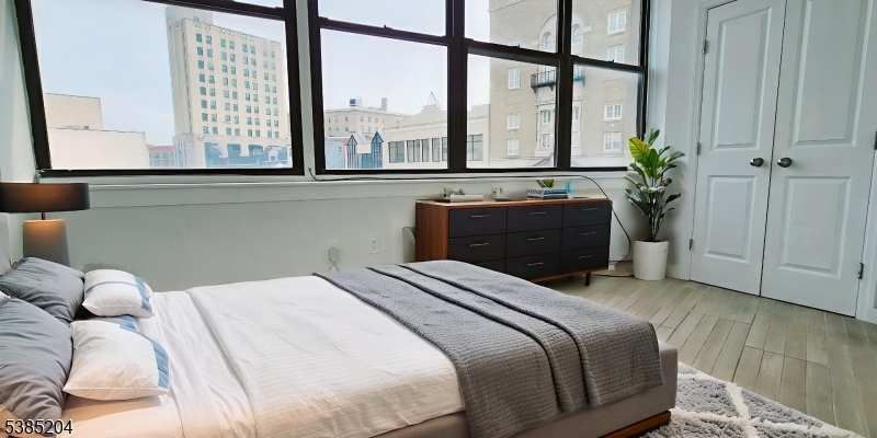 30 Howe Avenue, Unit 302 Passaic, NJ 07055 - Photo 6 of 10 a bedroom with a bed and a large window