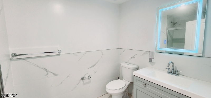 30 Howe Avenue, Unit 302 Passaic, NJ 07055 - Photo 7 of 10 a bathroom with a sink vanity mirror and toilet