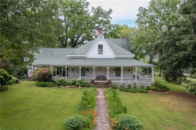 a front view of a house with a yard and potted plants