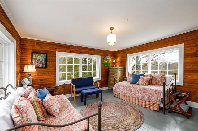 a white bench sitting in the grass near a house