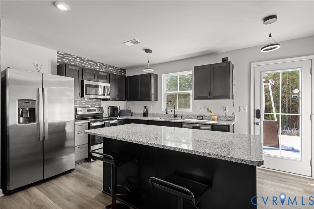5466 Niles Road Richmond, VA 23234 - Photo 13 of 31 a large kitchen with granite countertop a stove a sink dishwasher a refrigerator and a microwave