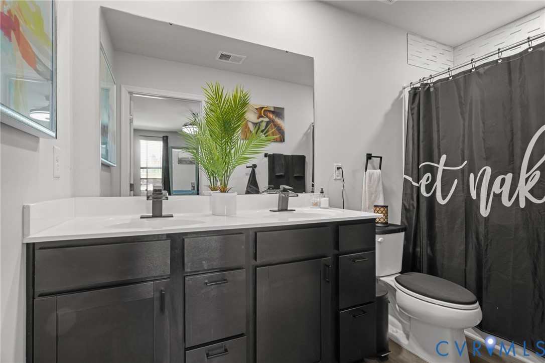 5466 Niles Road Richmond, VA 23234 - Photo 29 of 31 a bathroom with a double vanity sink toilet and a mirror
