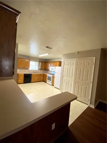 a kitchen with kitchen island a stove and a refrigerator