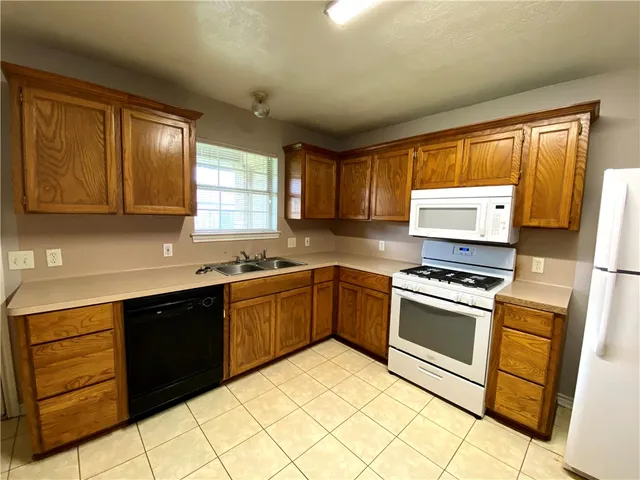 a kitchen with stainless steel appliances granite countertop a stove sink and cabinets