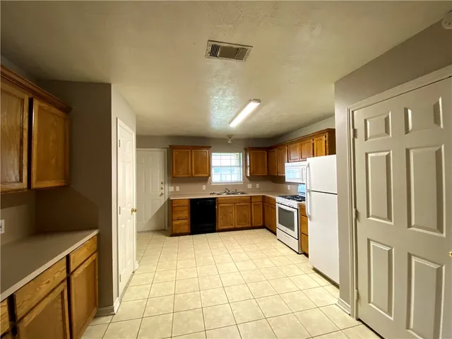 a large kitchen with a large counter top and stainless steel appliances