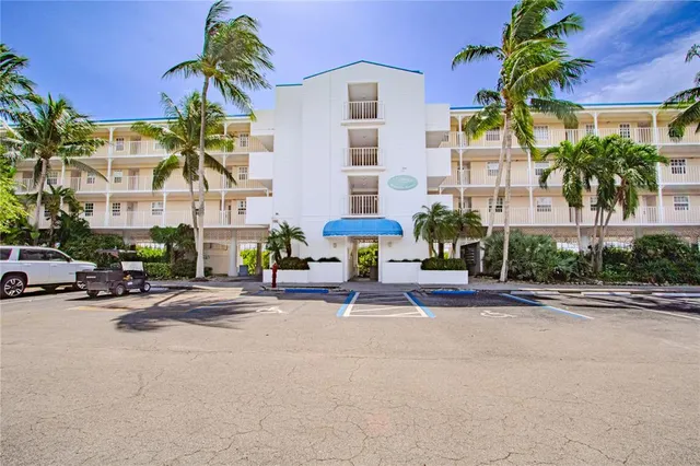 a row of palm trees in front of a building
