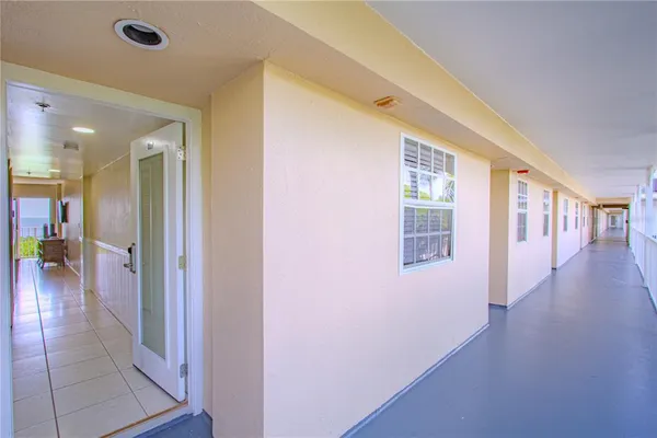 a view of a hallway with wooden floor and a living room