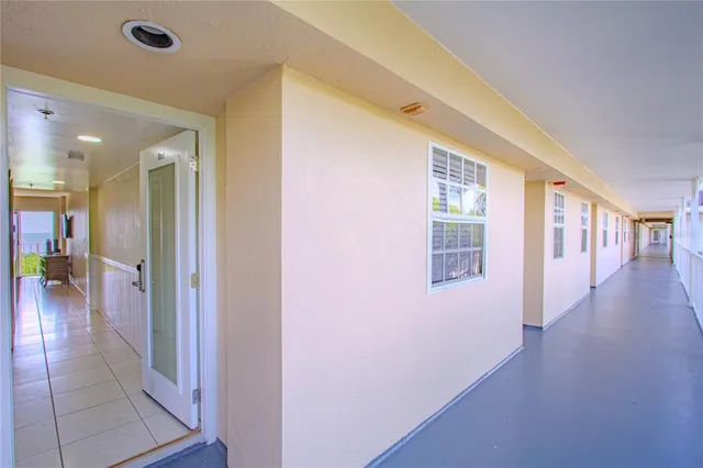 a view of a hallway with wooden floor and a living room
