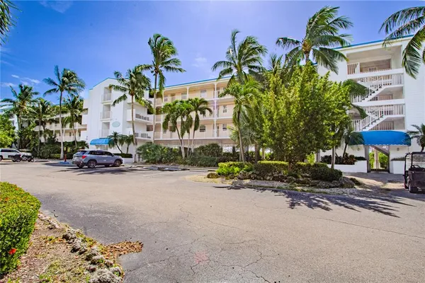 a row of palm trees in front of a house