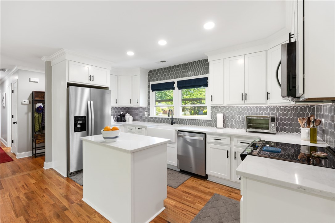 209 Manley Drive Clemson, SC 29631 - Photo 17 of 44 Bright, open-concept kitchen features elegant white cabinetry and durable hardwood flooring.