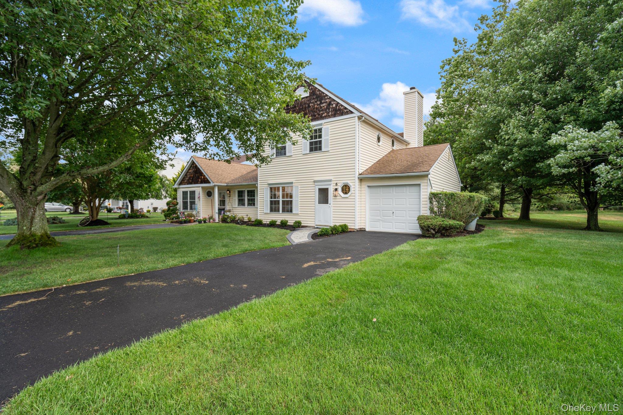 6 Doe Path Coram, NY 11727 - Photo 1 of 48 Traditional-style home with a garage, driveway, a chimney, a front lawn, and a shingled roof