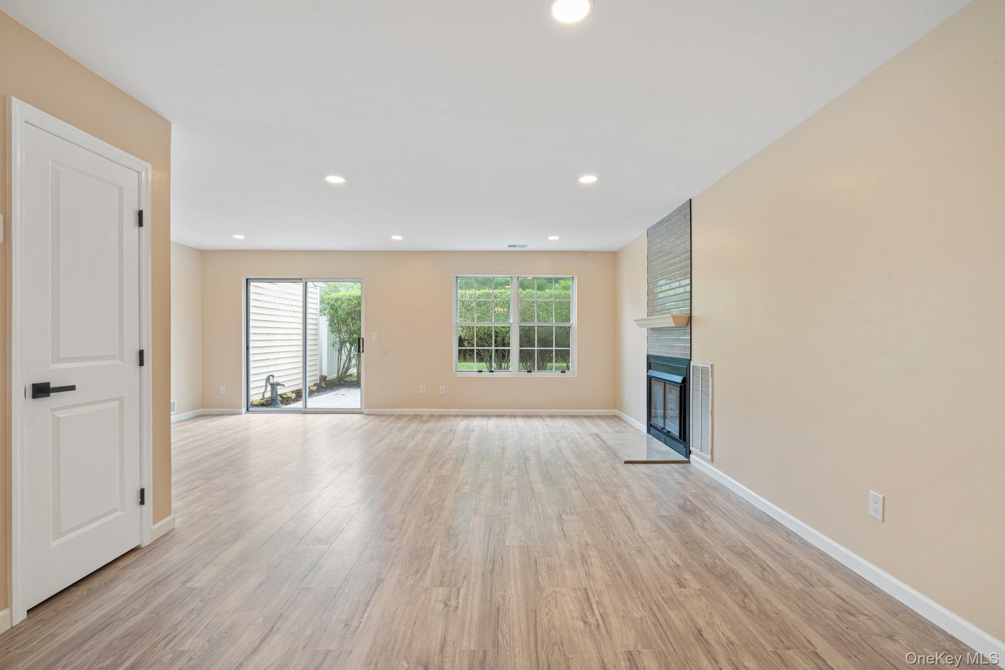 6 Doe Path Coram, NY 11727 - Photo 10 of 48 -Unfurnished living room featuring light wood-style flooring, a fireplace, and recessed lighting