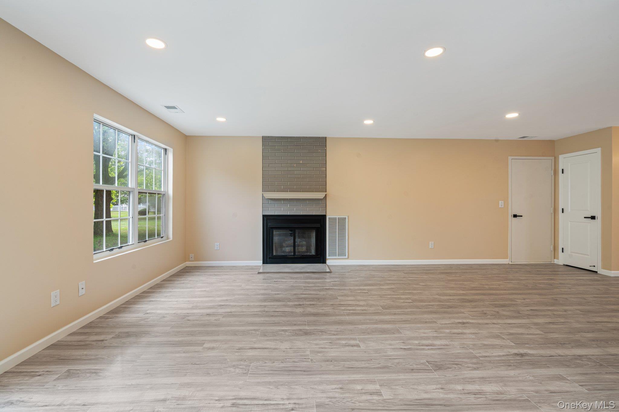 6 Doe Path Coram, NY 11727 - Photo 11 of 48 Unfurnished living room with recessed lighting, a fireplace, and light wood-style floors
