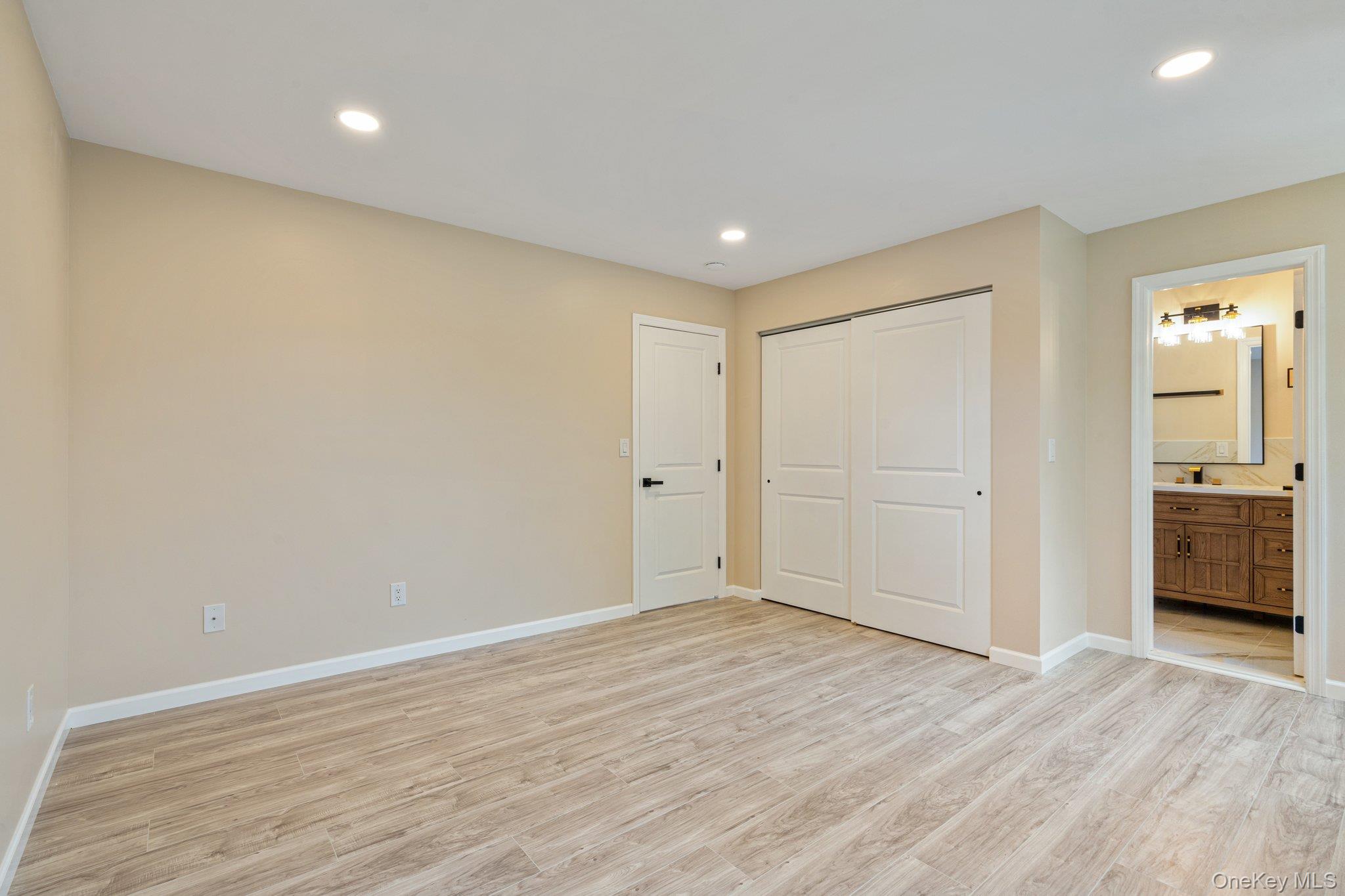 6 Doe Path Coram, NY 11727 - Photo 18 of 48 Unfurnished bedroom with light wood-style flooring, connected bathroom, a closet, and recessed lighting