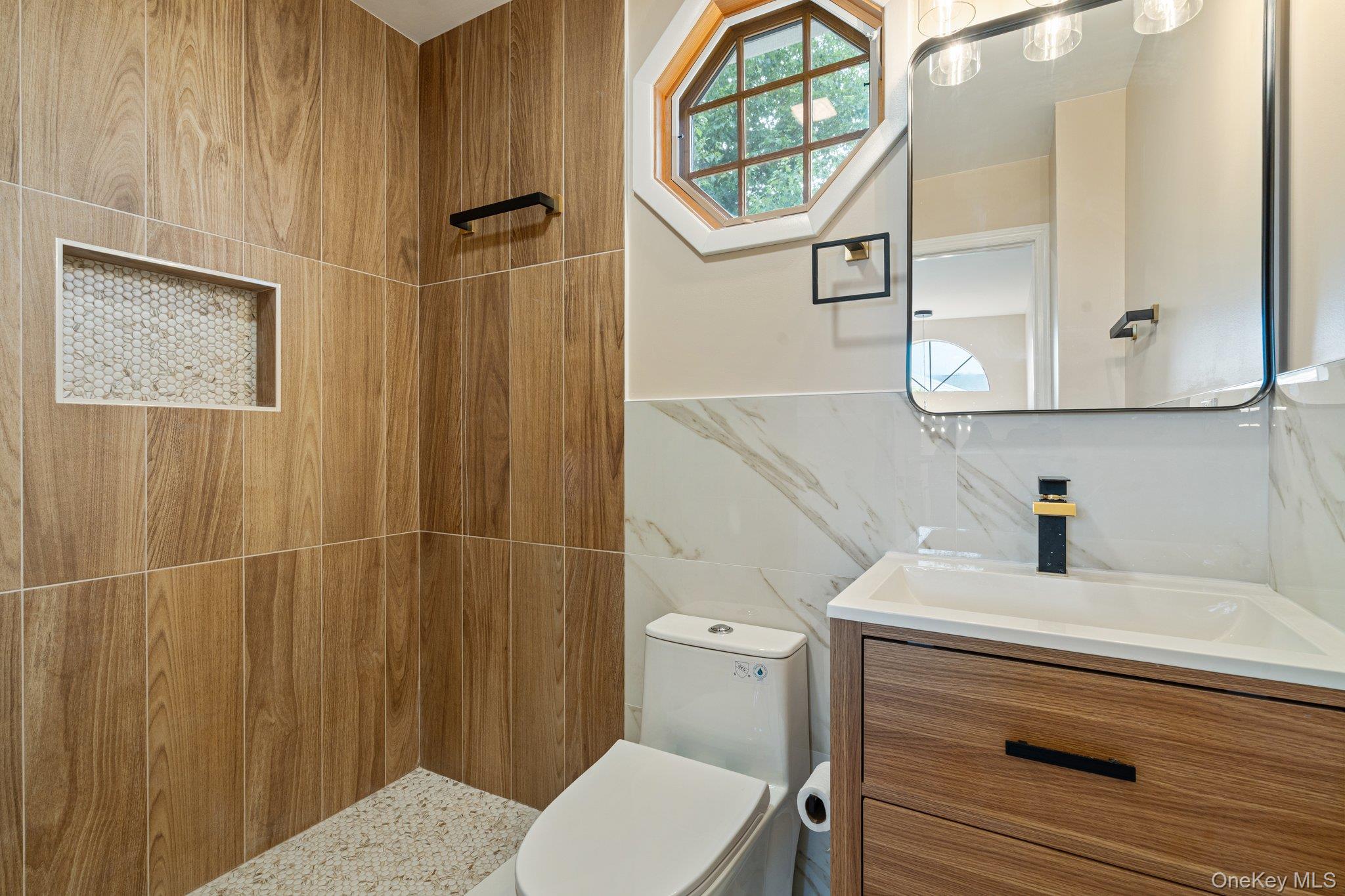 6 Doe Path Coram, NY 11727 - Photo 23 of 48 Bathroom featuring tile walls, a tile shower, vanity, and wainscoting