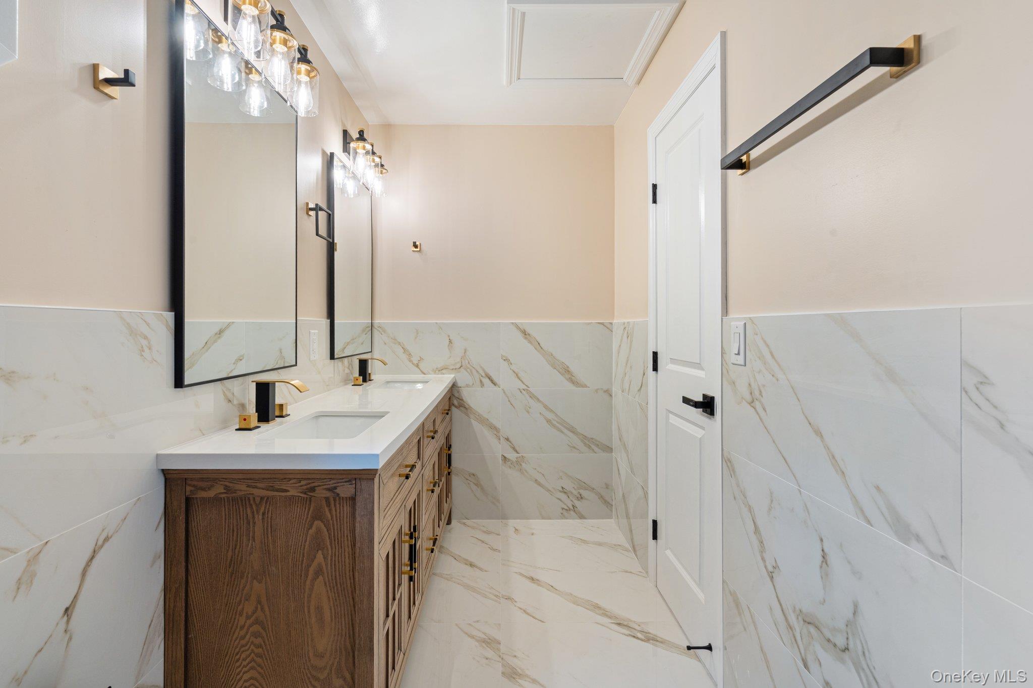 6 Doe Path Coram, NY 11727 - Photo 25 of 48 Full bathroom with tile walls, double vanity, marble tiled floors, and a wainscoted wall