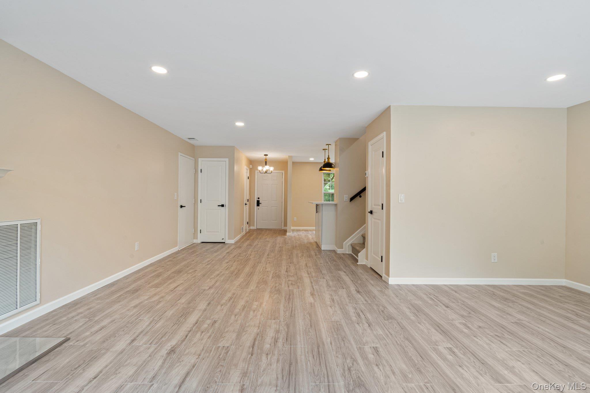 6 Doe Path Coram, NY 11727 - Photo 9 of 48 Unfurnished living room with stairway, recessed lighting, light wood finished floors, and a chandelier