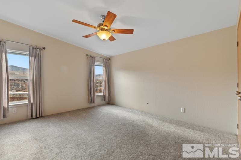 15085 Westwind Circle Reno, NV 89521 - Photo 11 of 28 an empty room with a ceiling fan and window