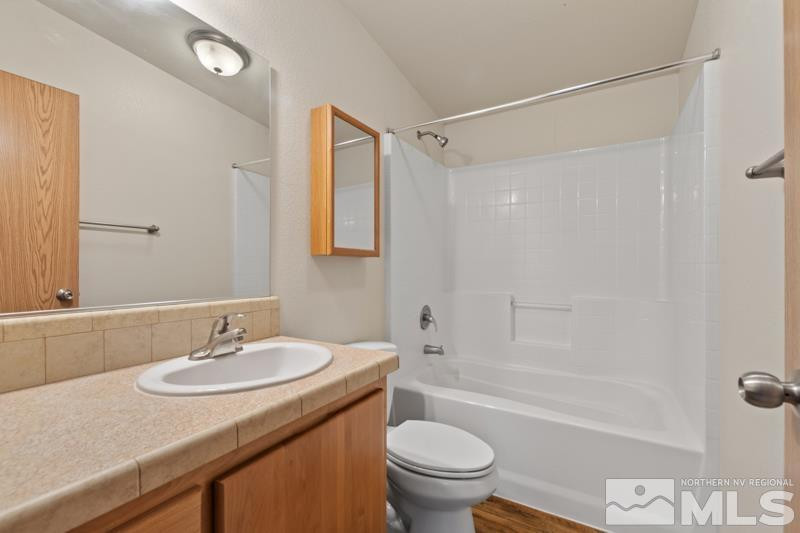 15085 Westwind Circle Reno, NV 89521 - Photo 17 of 28 a bathroom with a granite countertop sink toilet and shower