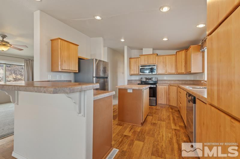 15085 Westwind Circle Reno, NV 89521 - Photo 5 of 28 a kitchen with stainless steel appliances granite countertop a refrigerator a stove top oven a sink and dishwasher