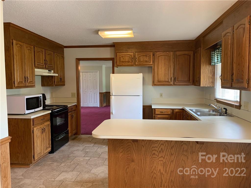 954 Old Charlotte Road Southwest Concord, NC 28027 - Photo 5 of 15 a kitchen with a sink a stove and refrigerator
