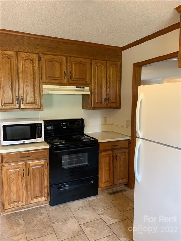 954 Old Charlotte Road Southwest Concord, NC 28027 - Photo 6 of 15 a kitchen with a refrigerator and a stove