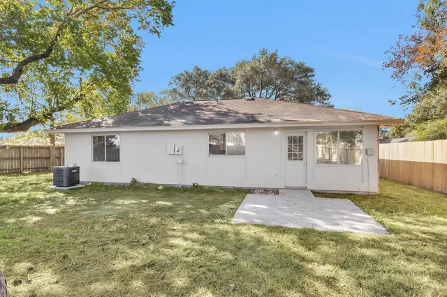 a view of a house with backyard and a tree